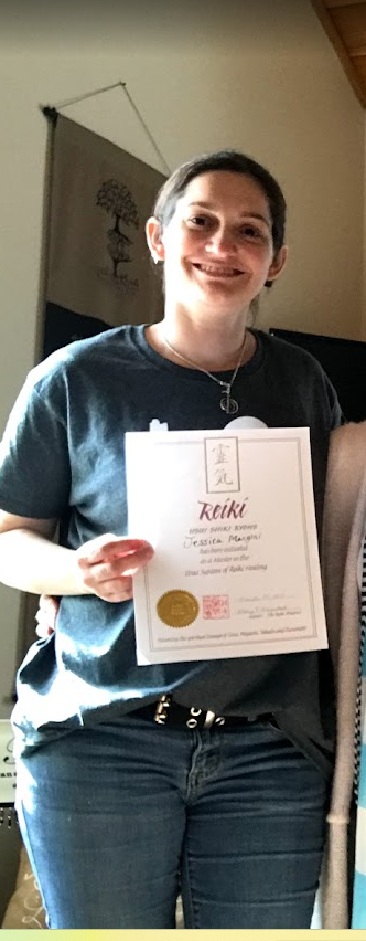 Jess holding her Reiki master certificate